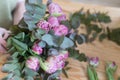 Close-up - professional florist creates a bouquet of eucalyptus and tulips. Work behind the counter of a flower shop Royalty Free Stock Photo