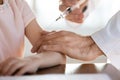 Professional medical worker making vaccination prick to little patient.