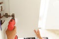 Close up of professional repairman is using a screwdriver to adjust door of cabinet in kitchen Royalty Free Stock Photo