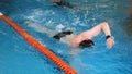 Close up for professional swimmer in slow mothion while swimming race in indoor pool. Athlete training, swimming the Royalty Free Stock Photo