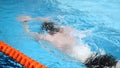 Close up for professional swimmer in slow mothion while swimming race in indoor pool. Athlete training, swimming the Royalty Free Stock Photo