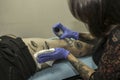 Close up professional woman tattooer cleaning tattoo in a man le