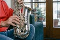 close up in profile with copy space of male hands playing a saxophone inside home Royalty Free Stock Photo