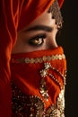 Studio shot of a young charming woman wearing the terracotta hijab decorated with sequins and jewelry. Arabic style. Royalty Free Stock Photo