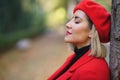 Close-up profile picture of a middle-aged woman leaning against a tree trunk with her eyes closed. Royalty Free Stock Photo