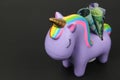 A close up profile of a piggy bank with Canadian bank notes Dollars. Unicorn bank with money on black background