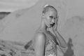 Close-up profile portrait of a beautiful young woman posing in the desert, looking at camera. Black and white image. Royalty Free Stock Photo