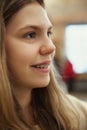 Close up profile portrait of young cute girl smiling with teeth in braces looking away against blurred background. Royalty Free Stock Photo