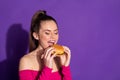 Close-up profile side view portrait of attractive dreamy cheery eating delicious burger copy space isolated on bright Royalty Free Stock Photo