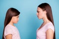 Close-up profile side view portrait of two nice attractive offended irritated straight-haired girls looking frowning at