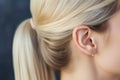 Close-up profile unrecognizable young blonde Caucasian woman head girl lady female human ear elegant earring jewelry Royalty Free Stock Photo