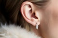 Close-up profile unrecognizable young blonde Caucasian woman head girl lady female human ear elegant earring jewelry Royalty Free Stock Photo