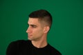 Close up profile view of young handsome man isolated against emotions of a handsome man guy on a green background Royalty Free Stock Photo