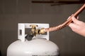 Man tries to fit a copper pipe onto a propane bottle Royalty Free Stock Photo