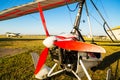 Close up of propellerof motor hang glider standing on green grass at aerodrome, bright summer day