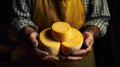 Close-up of a proud cheese maker exhibiting his cheese expertise. cheese in hands