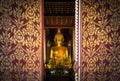 Close up public golden buddha statue looks through entrance door in wat Phra That Chae Haeng public temple at Nan