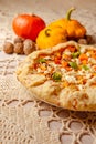 close up pumpkin pie galette, open pie on beige knitted tablecloth on table in cozy kitchen. atmospheric evening warm lighting