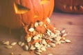 Close up on Pumpkin puking with pumpkin seeds on wood table