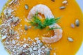 Close-up pumpkin soup with prawns, pumpkin seeds whole and broken and decorated with dill Royalty Free Stock Photo