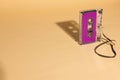 Close up of purple cassette tape with copy space on beige background Royalty Free Stock Photo