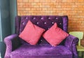 Purple luxury armchair in hotel lobby in vintage brick wall for guest reception Royalty Free Stock Photo