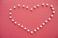 Close-up of push pins forming heart shaped over pink foreground Royalty Free Stock Photo