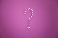 Close-up of push pins forming question mark over pink background Royalty Free Stock Photo