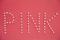 Close-up of push pins spelling pink over colored background Royalty Free Stock Photo