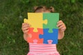 A close-up of a puzzle assembled from colored parts in the hands of small child Royalty Free Stock Photo