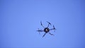 Close-up of quadcopter flying in sky. Clip. Large quadcopter with powerful motors flying on background blue sky