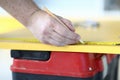 Close-up of qualified construction site worker using pencil for notes