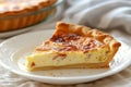 Close-up of Quiche Lorraine slice with bacon, onion and chicken eggs. Baked custard dough served on white plate. Classic