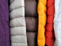 Close up of quilted sewing on puffy warm jackets hanging together