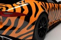 A close up of a race car with a bright orange and black zebra livery. Speed drive concept. AI generation