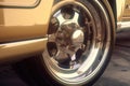 Close up of a racing wheel with its chrome trim gleaming in the sunlight. Speed drive concept. AI generation