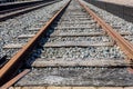 Close-up of an railroad tracks with its rusty rails and wooden sleepers among the gravel Royalty Free Stock Photo