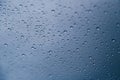 Close up of rain drops on window with blue gray background of dark sky Royalty Free Stock Photo