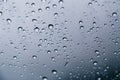 Close up of rain drops on the windshield, front window of a car on a blue gray background of dark sky Royalty Free Stock Photo