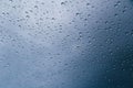 Close up of rain drops on the windshield, front window of a car on a blue gray background of dark sky. Royalty Free Stock Photo