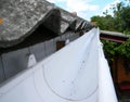 Close up on rain gutter pipeline on house rooftop with asbestos roof