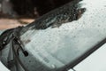 Close-up of raindrops on the windshield of a car in cloudy weather after rain outdoors. Side view, selective focus Royalty Free Stock Photo