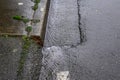 Close up of rainwater running down the edge of the street and sidewalk