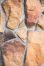 Close up of the decorative facade facing, made as asymmetric mosaic of natural stone of different sizes and shapes. Royalty Free Stock Photo
