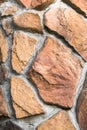 Close up of the decorative facade facing, made as asymmetric mosaic of natural stone of different sizes and shapes. Royalty Free Stock Photo