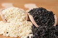 Close-up of raw black and white sesame seeds in wooden scoops. Low angle view