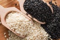 Close-up of raw black and white sesame seeds in wooden scoops. Top view