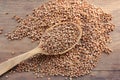 Close-up of raw buckwheat grain on a wooden spoon on wood table background. Royalty Free Stock Photo