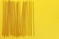 Close up of a raw dry italian pasta spaghetti on bright yellow background. Shooting with bold color.