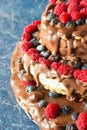 Close up raw healthy unbaked vegan cheesecake with chocolate, raspberries, blueberries and nuts Royalty Free Stock Photo